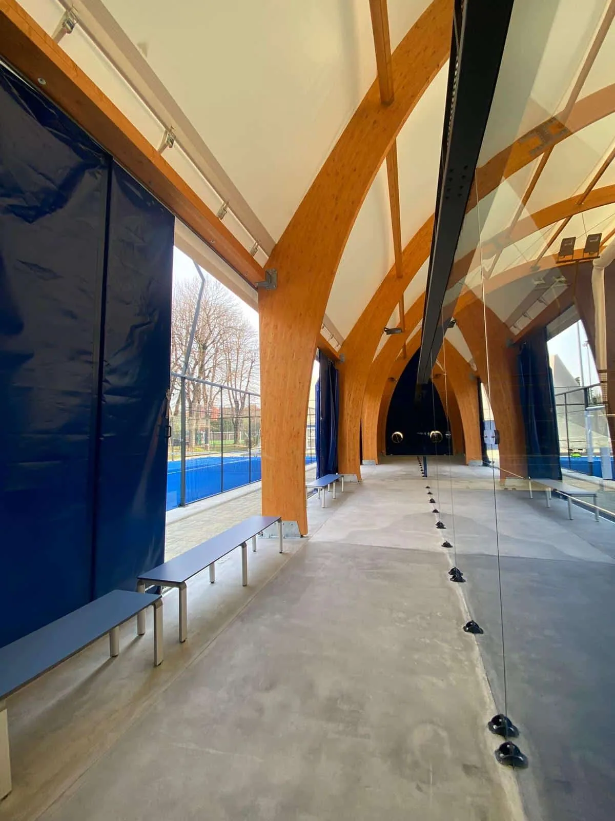 Allée couverte en bois le long de terrains de padel