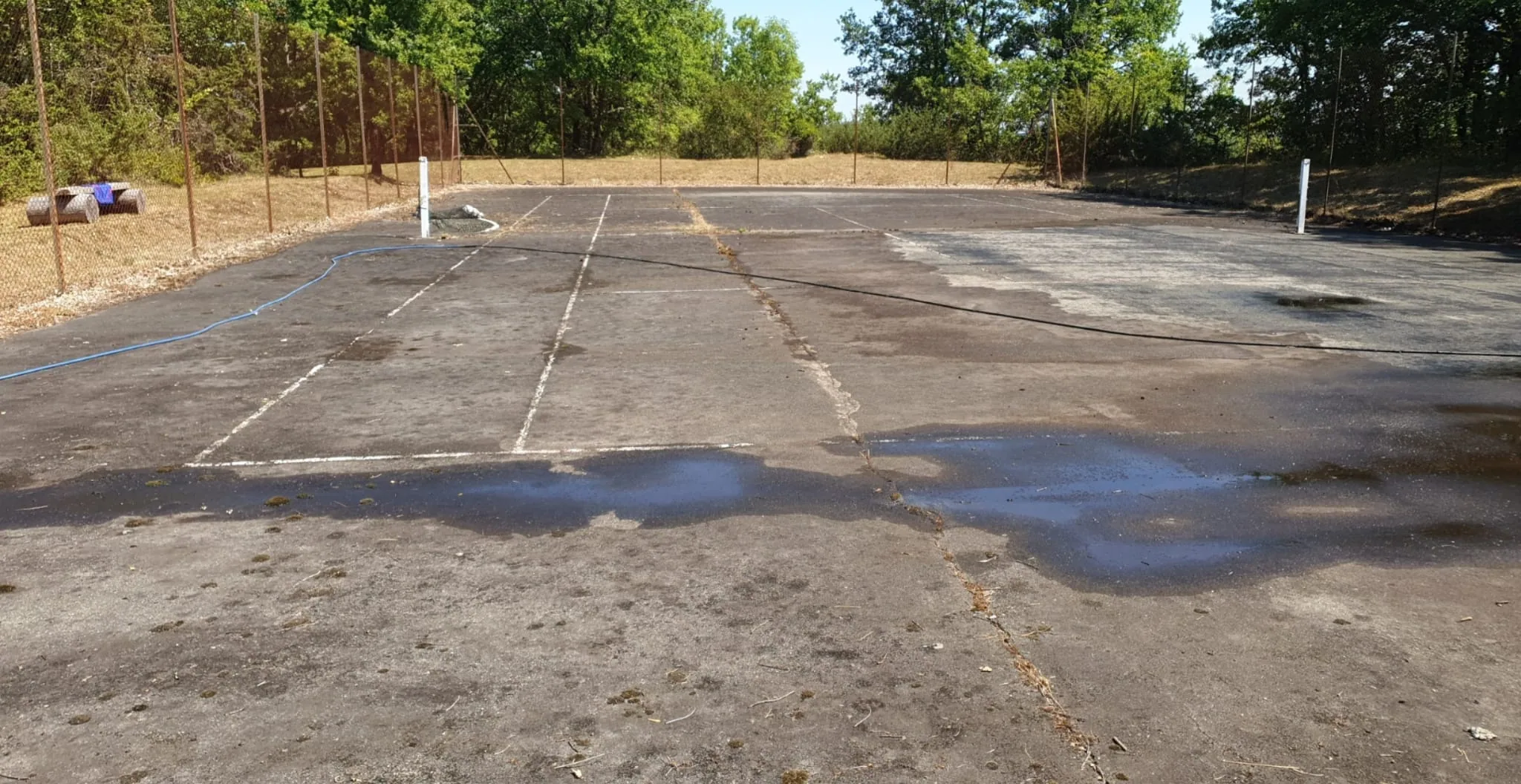 Ancien court de tennis fissuré et détrempé avant travaux