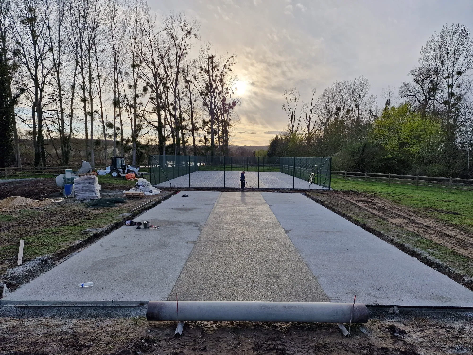 Chantier de court : dalle en préparation et clôture posée