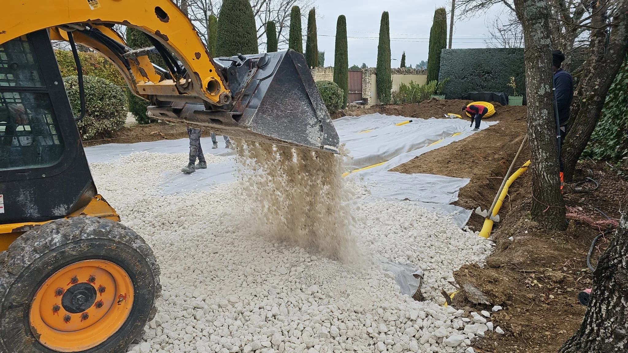 Chargeuse déversant du gravier pour la plateforme d'un court