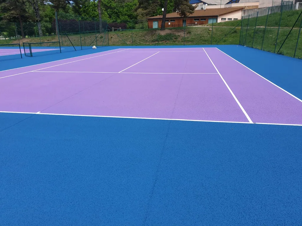 Court de tennis à aire de jeu violette et abords bleus