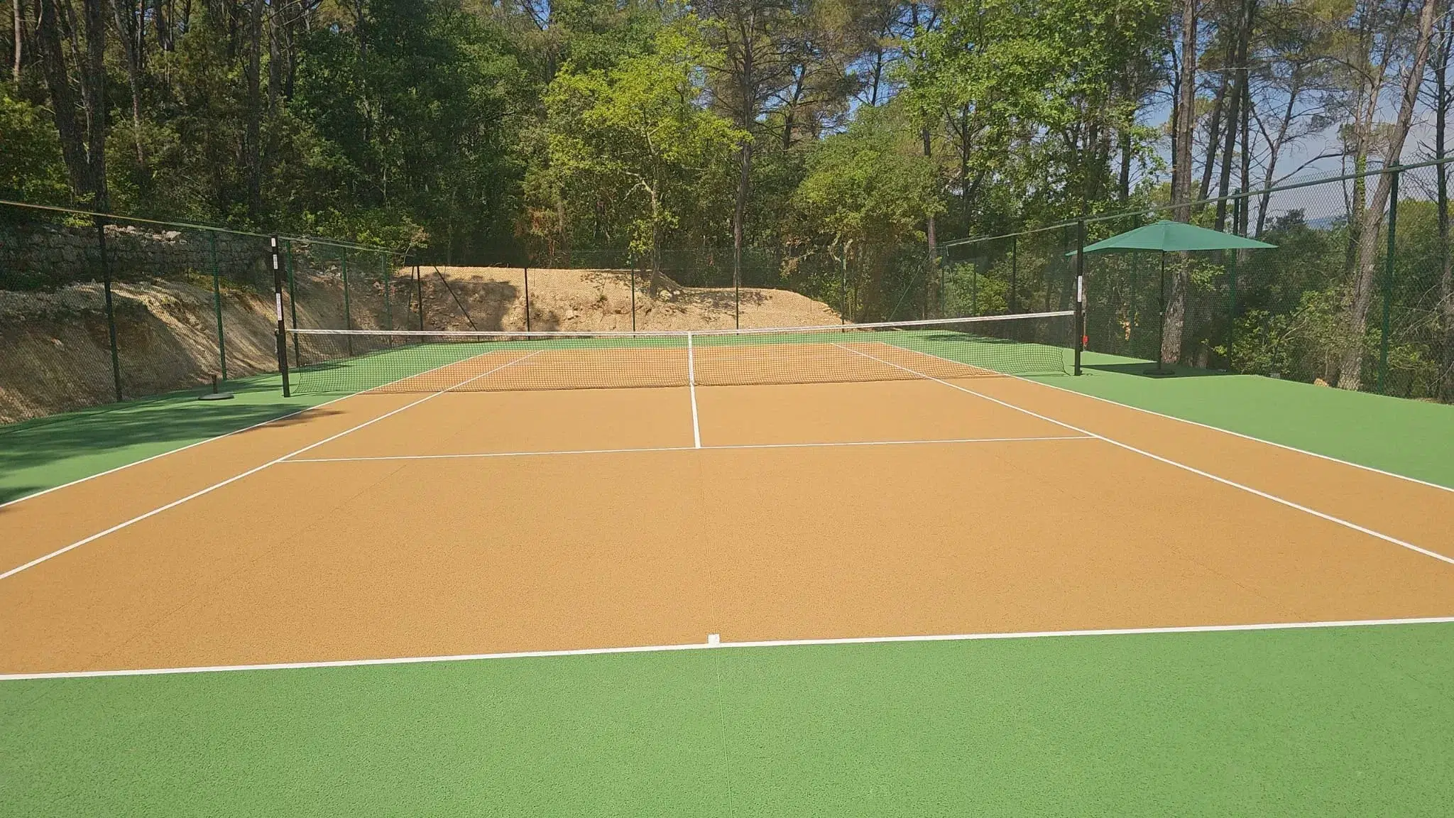 Court de tennis neuf couleur terre battue, vue d'ensemble