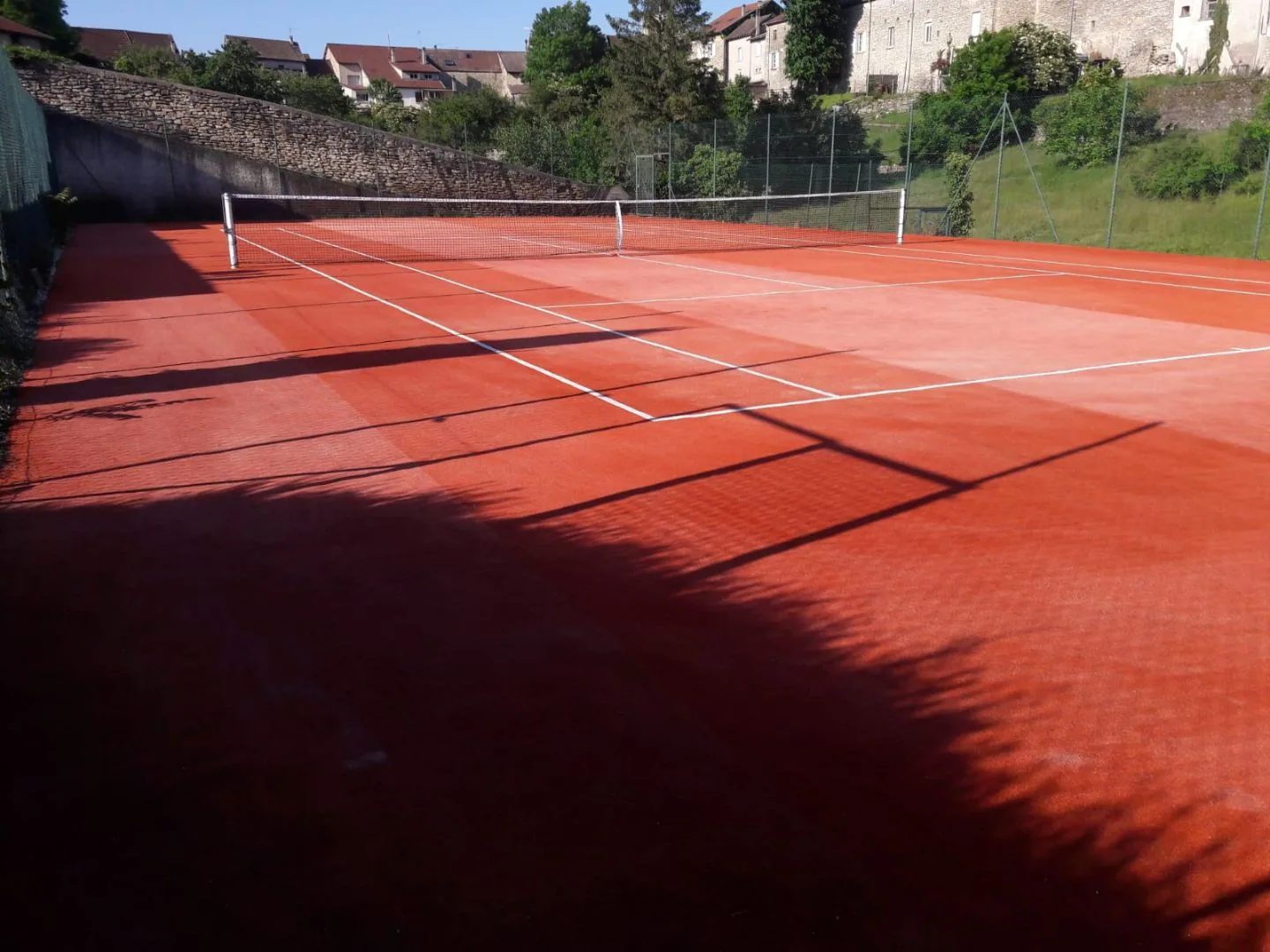 Court de tennis rouge en fin de journée
