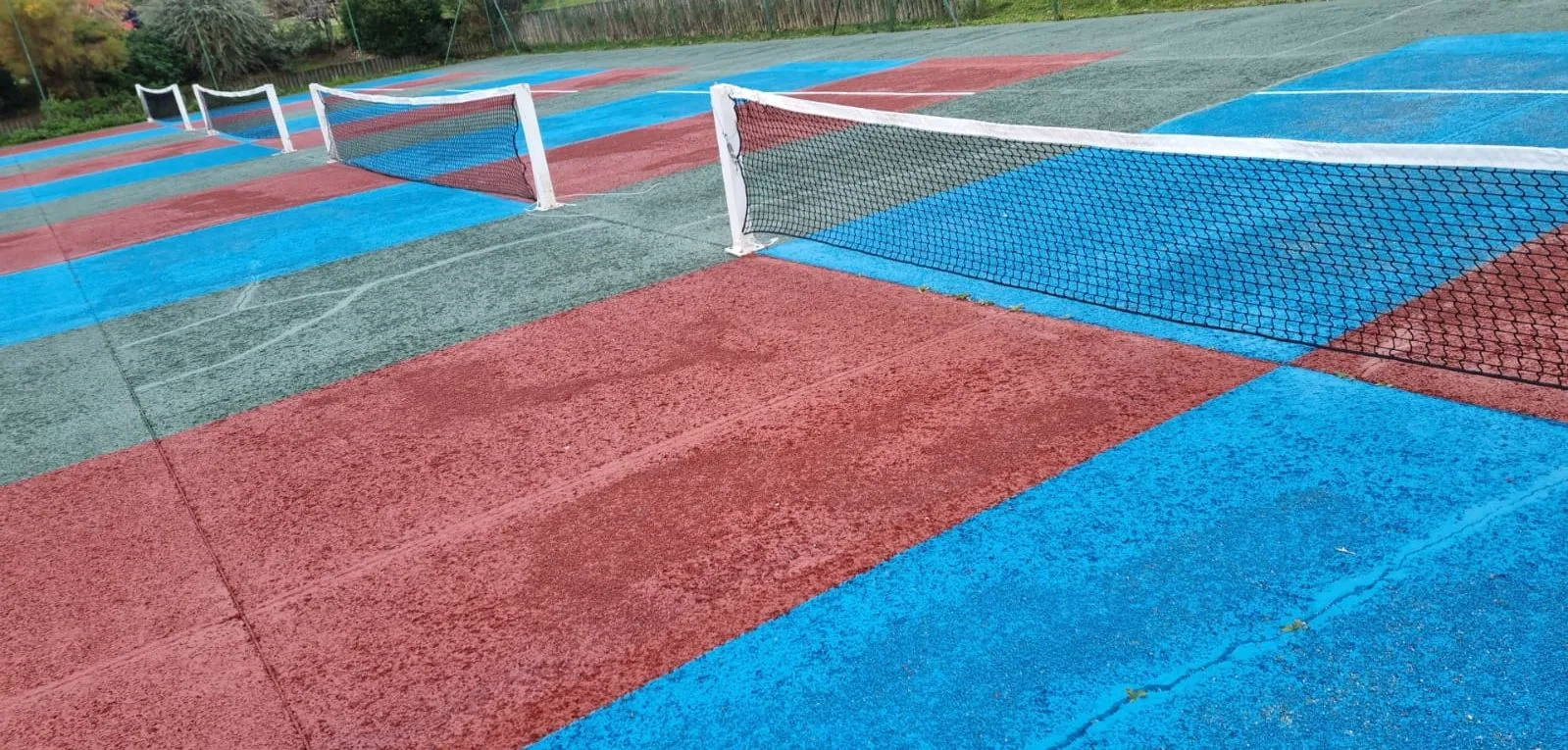 Court de tennis rouge et bleu d'un club, vue en surplomb