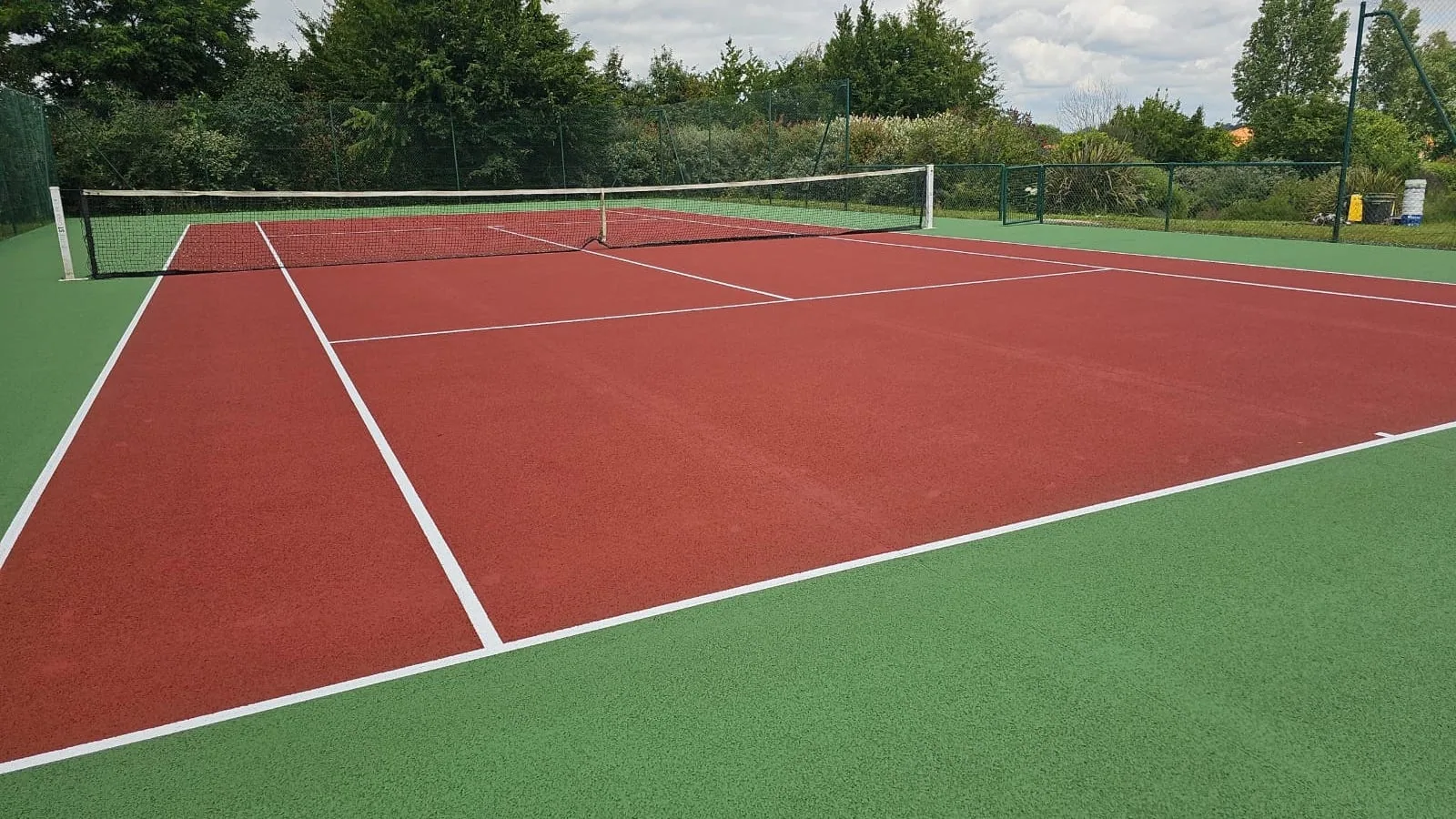Court de tennis rouge et vert après remise en peinture