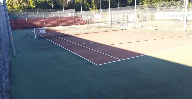 Court de tennis rouge et vert d'un club, vue d'ensemble