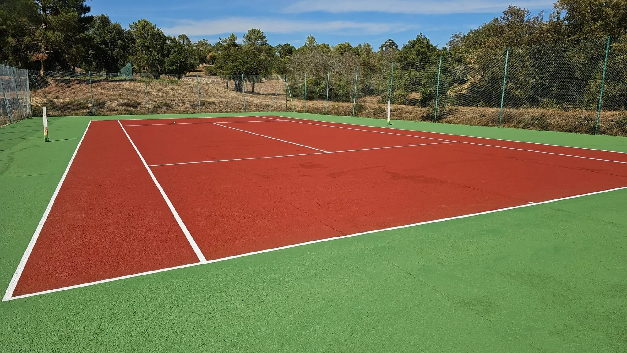 Court de tennis rouge et vert neuf en campagne