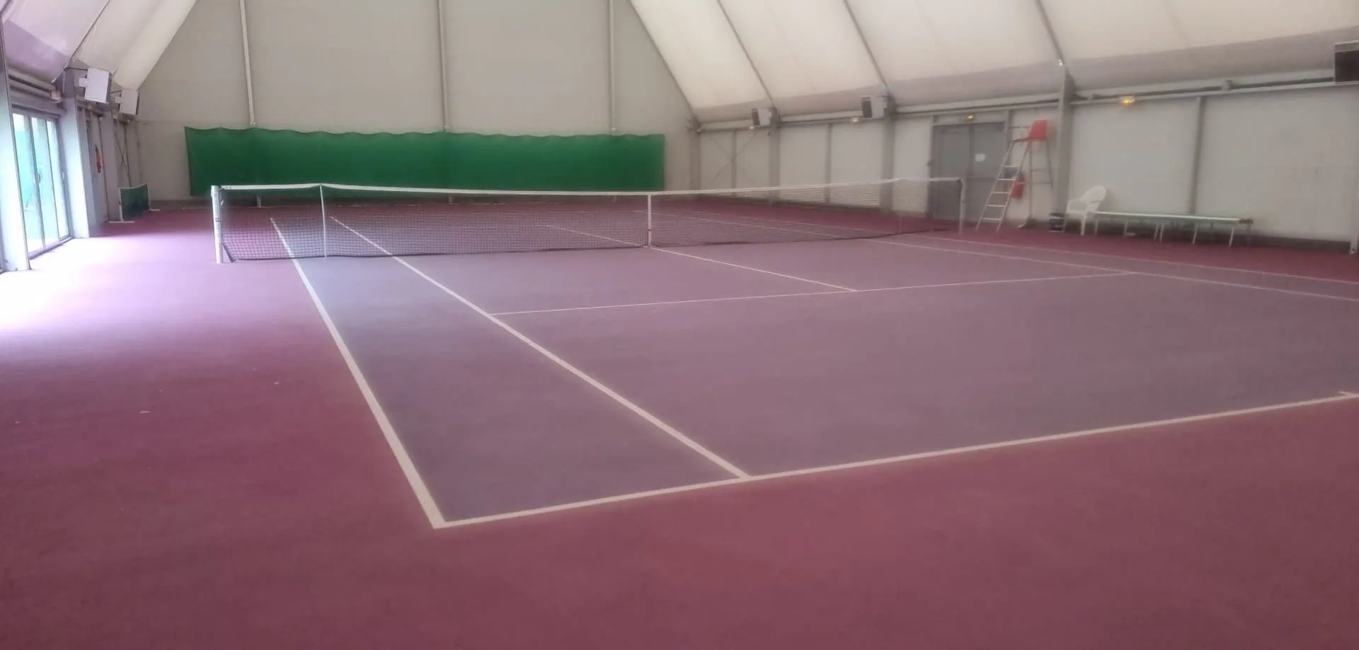 Court de tennis rouge et vert sous une couverture textile