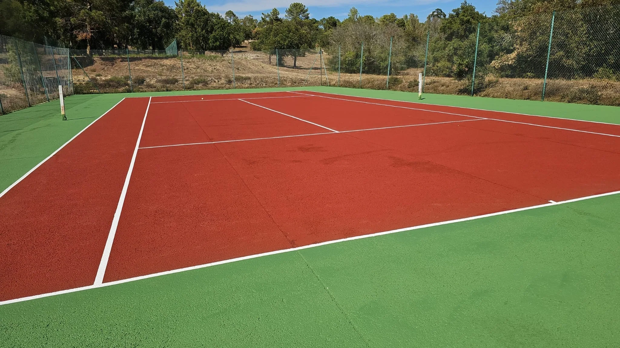 Court de tennis rouge et vert, vue latérale