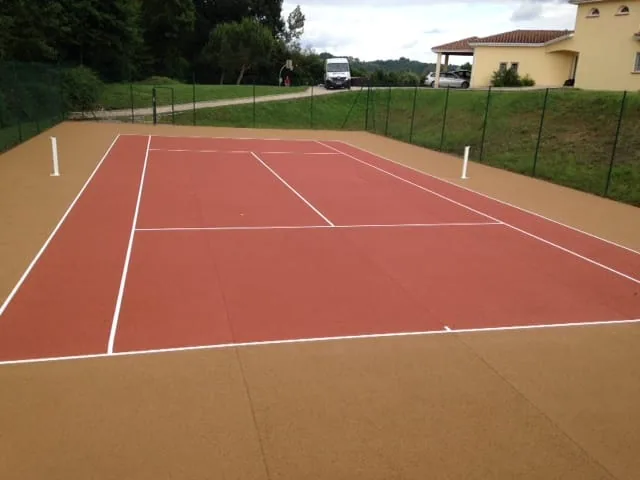 Court de tennis rouge-orangé après remise en peinture