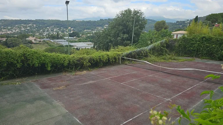 Court de tennis rouge terni en surplomb d'une vallée