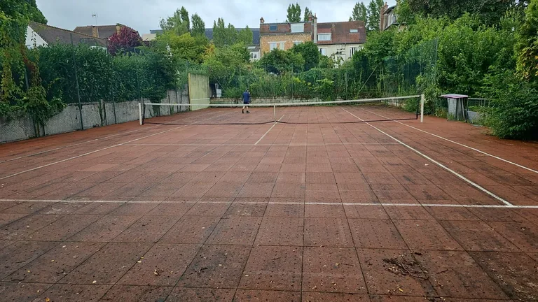 Court de tennis rouge très usé avant rénovation