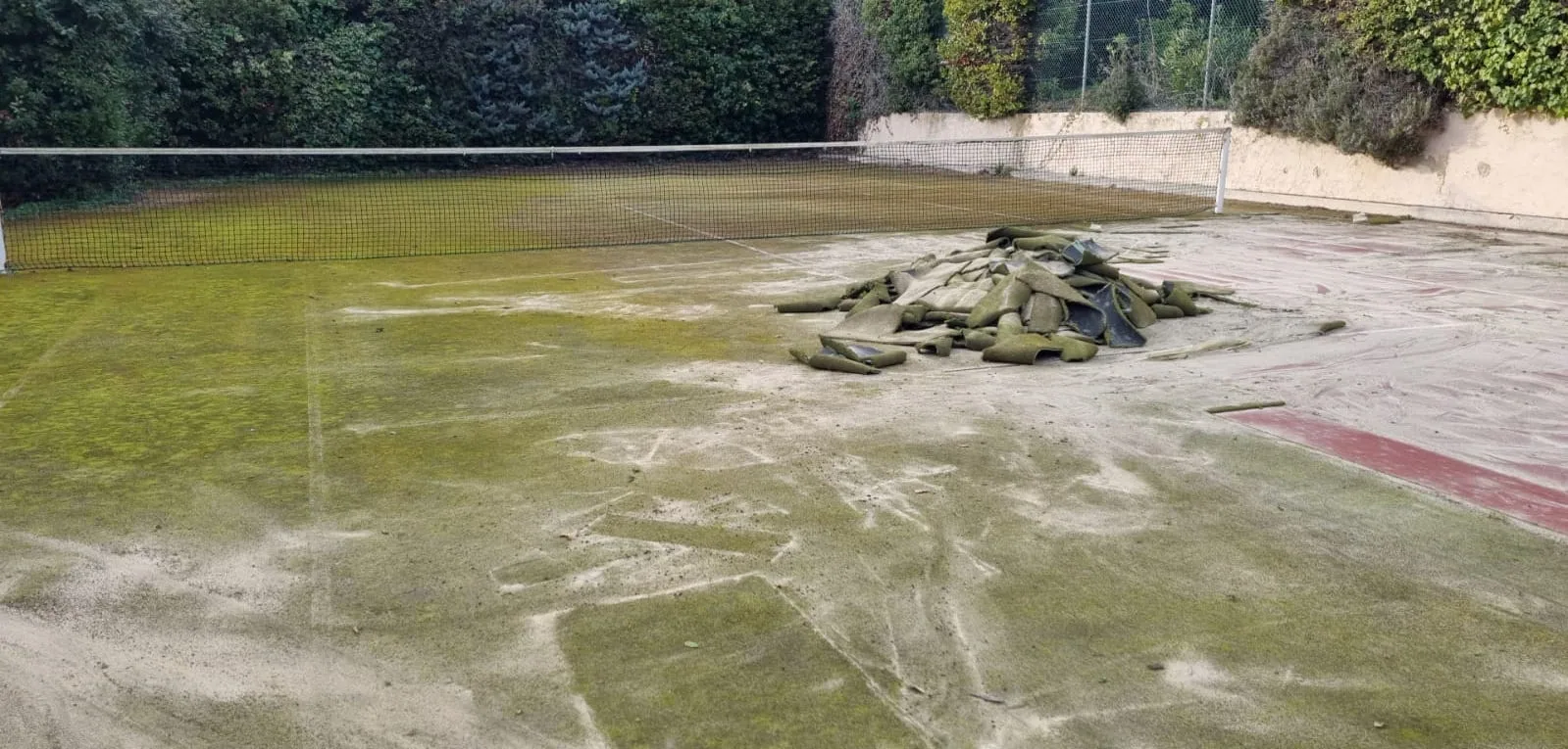 Court de tennis très encrassé par la mousse et la boue