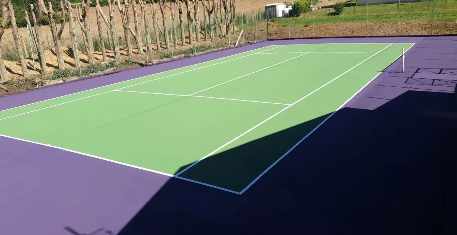 Court de tennis vert à abords violets