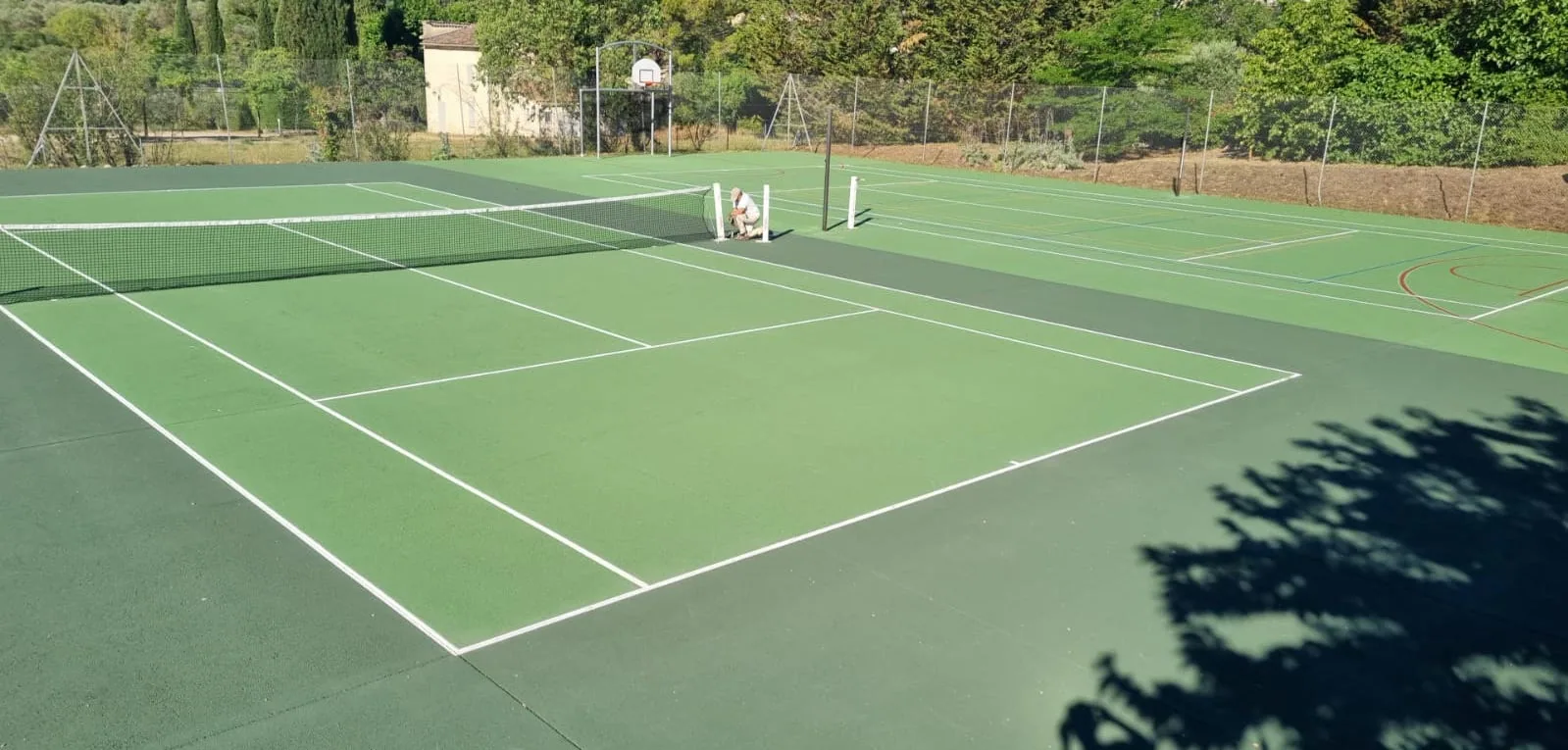 Court de tennis vert d'un club avec chaise d'arbitre
