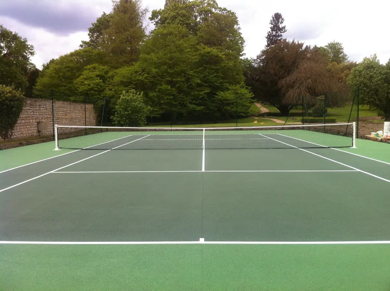 Court de tennis vert d'un parc aux lignes blanches neuves