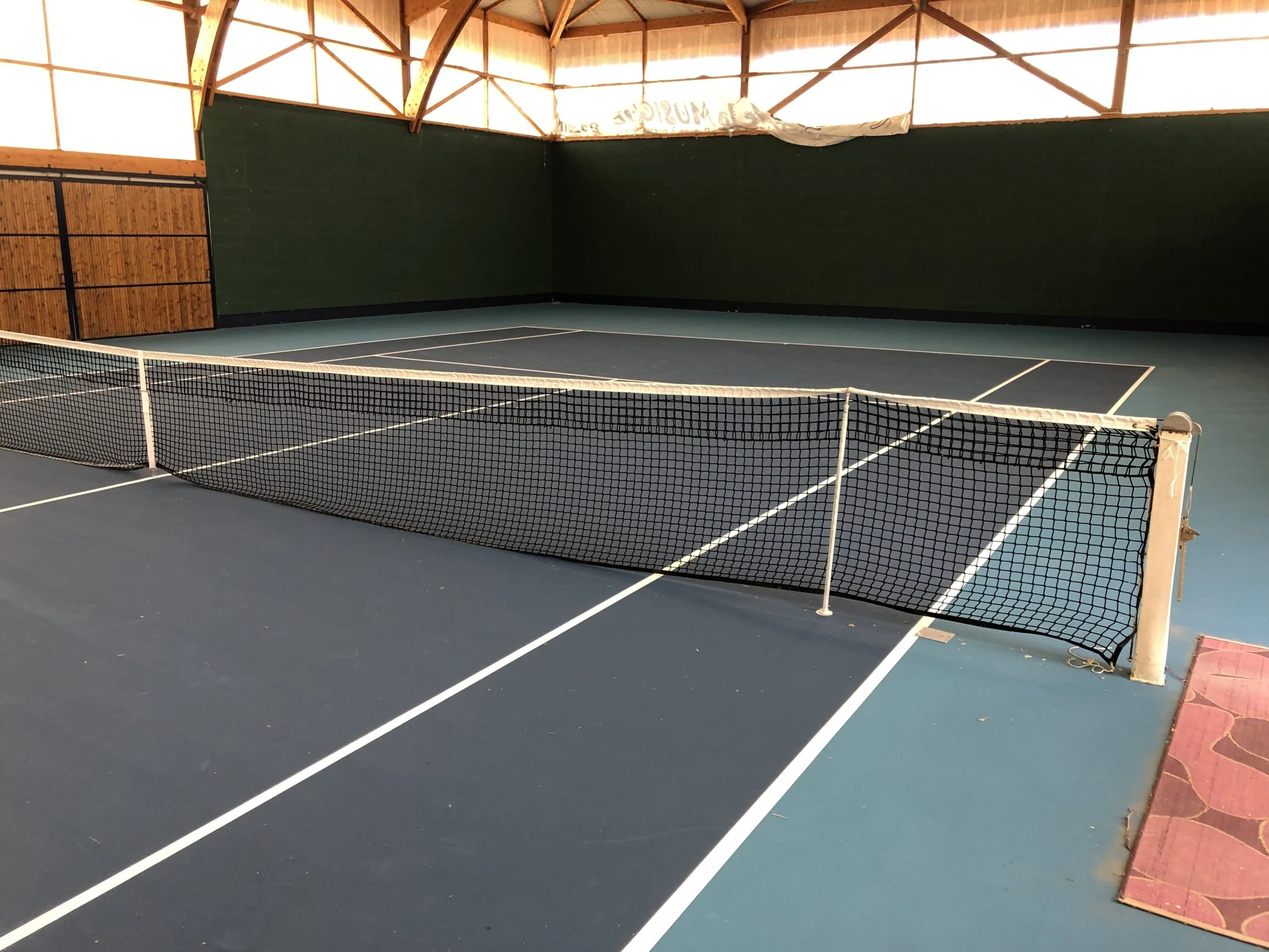 Court de tennis vert dans une salle couverte