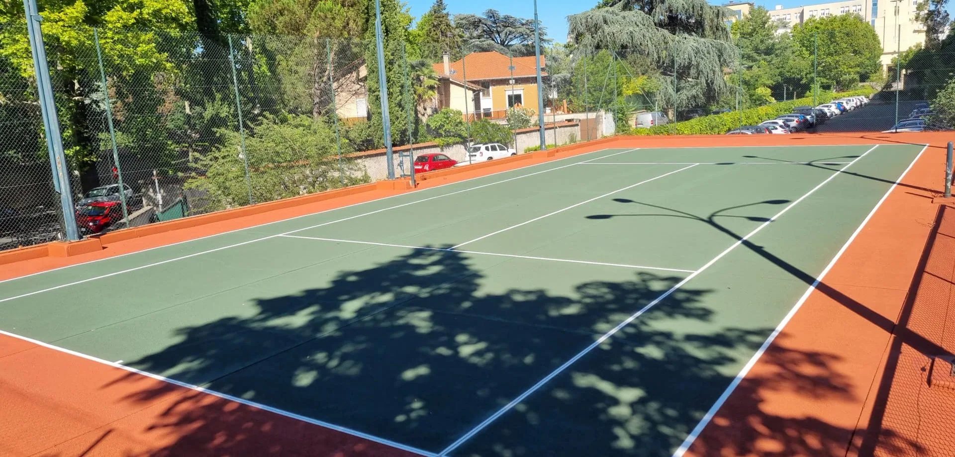 Court de tennis vert et rouge d'un club en ville