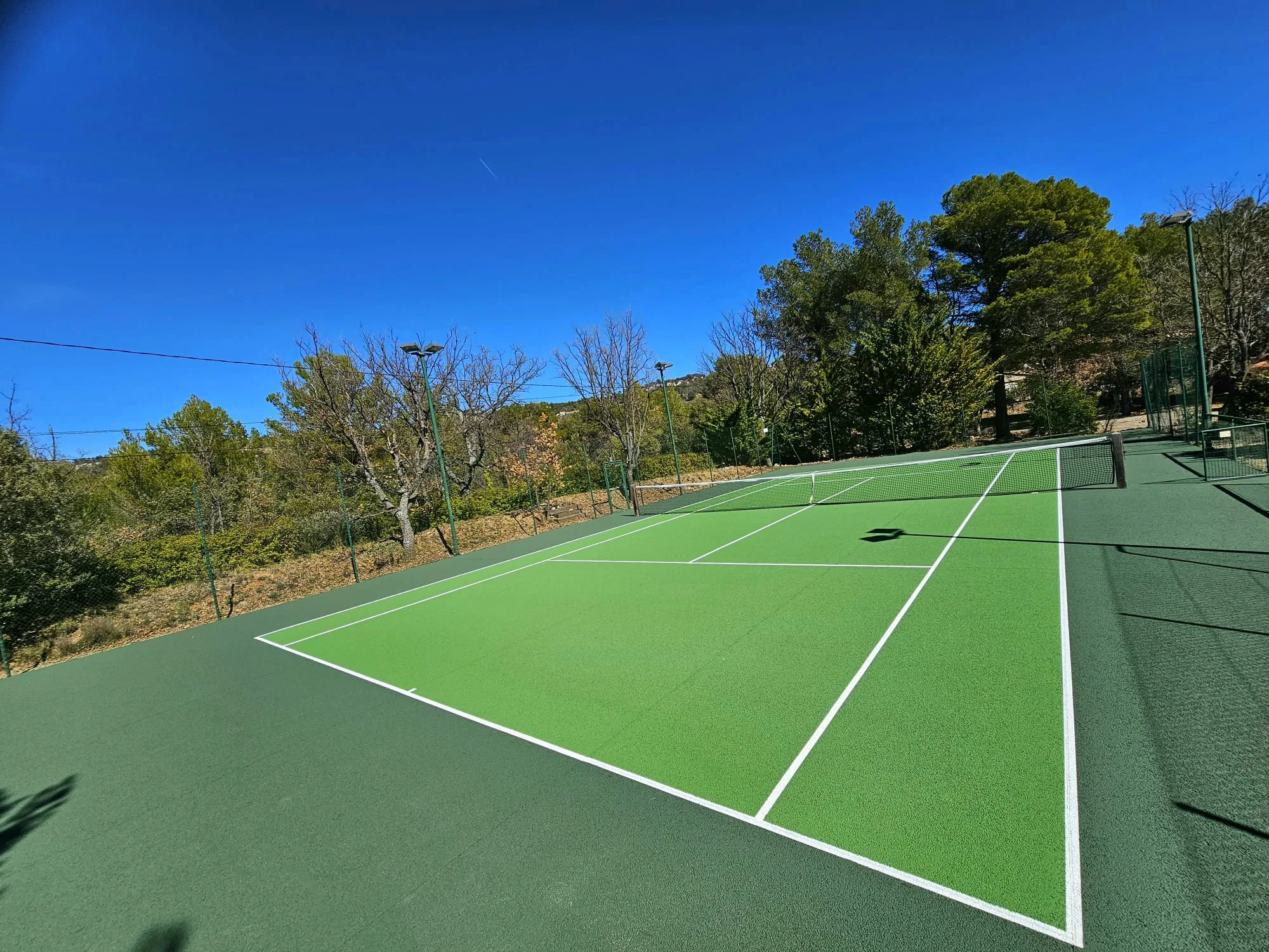 Court en gazon synthétique vert sous un ciel bleu
