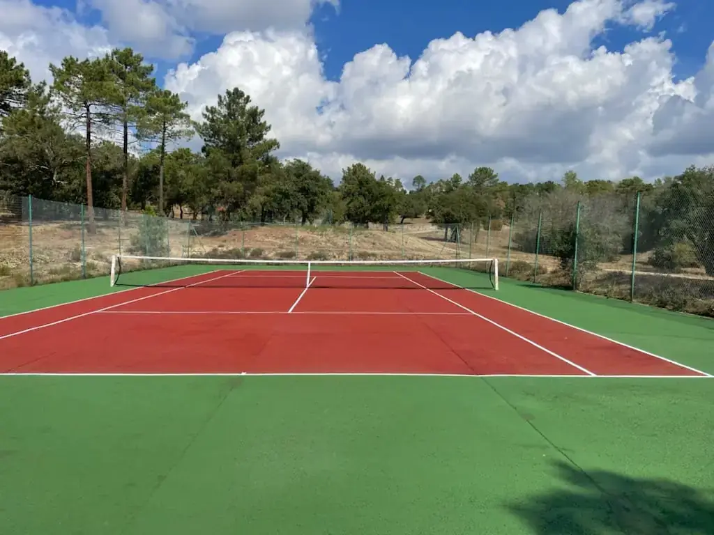 Court de tennis rouge et vert en pleine nature
