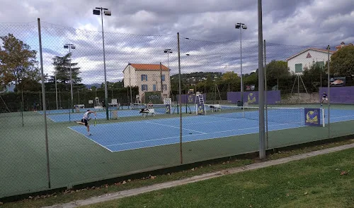 Courts de tennis bleus d'un club sous un ciel nuageux
