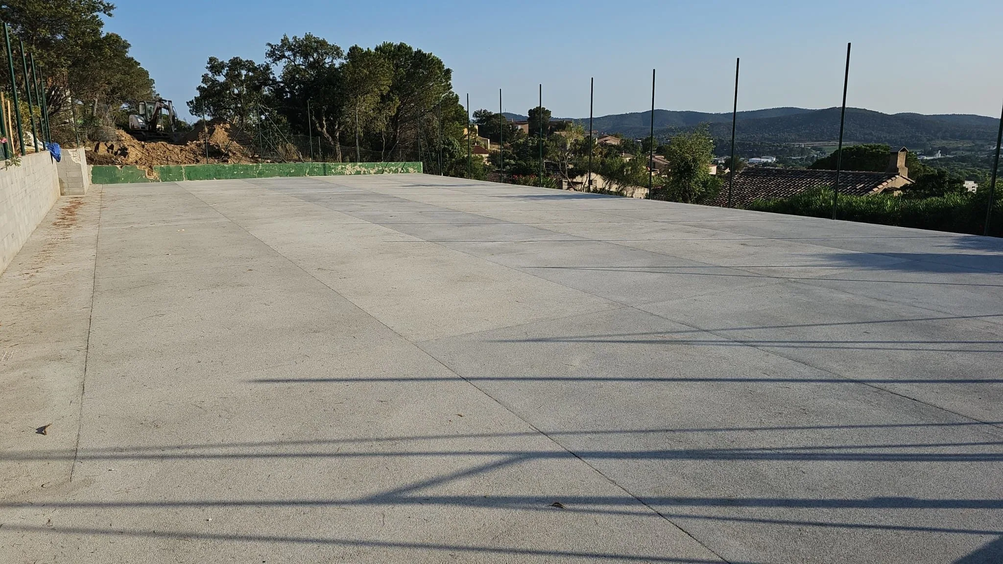 Dalle de béton d'un court avec vue sur les collines