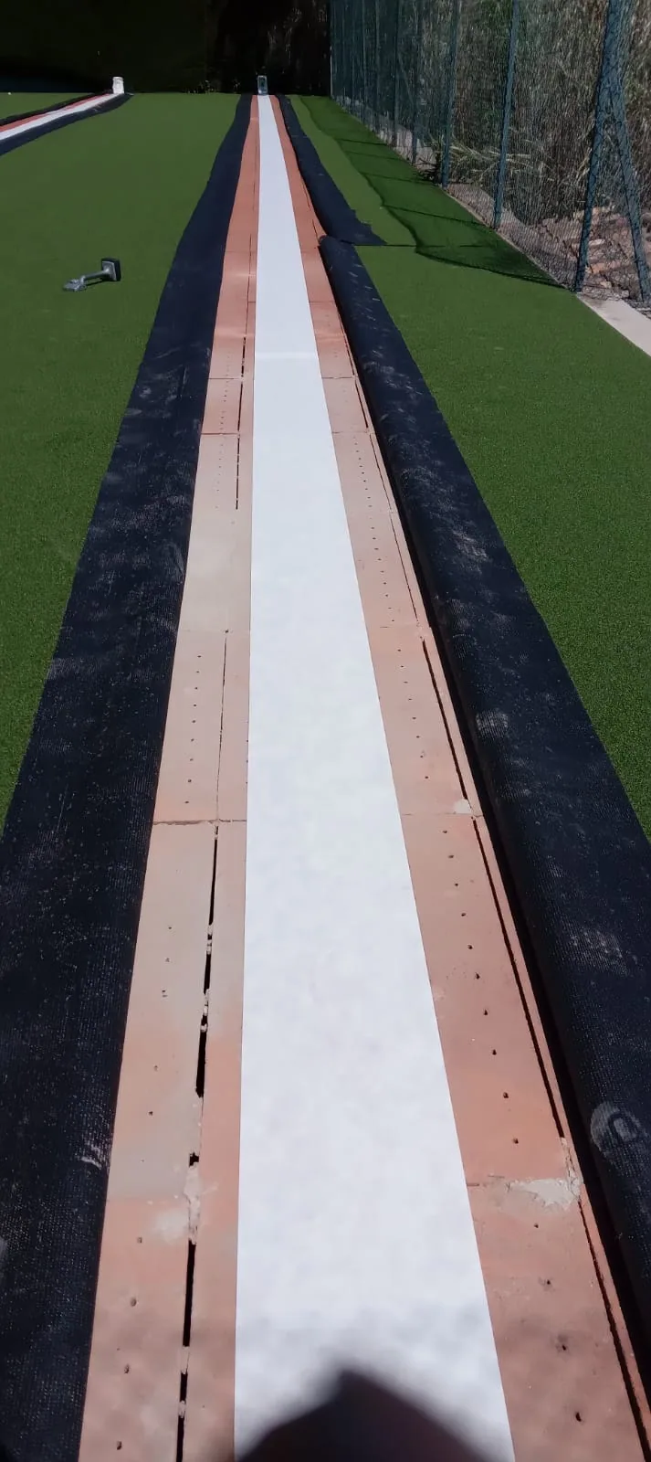 Ligne blanche en cours de pose sur un gazon synthétique