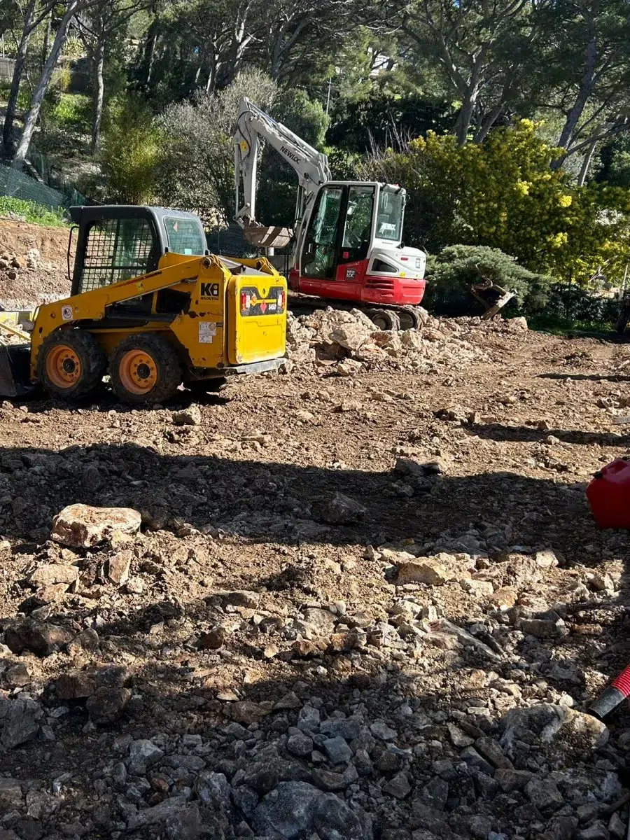 Mini-chargeuse et pelleteuse sur le chantier d'un court