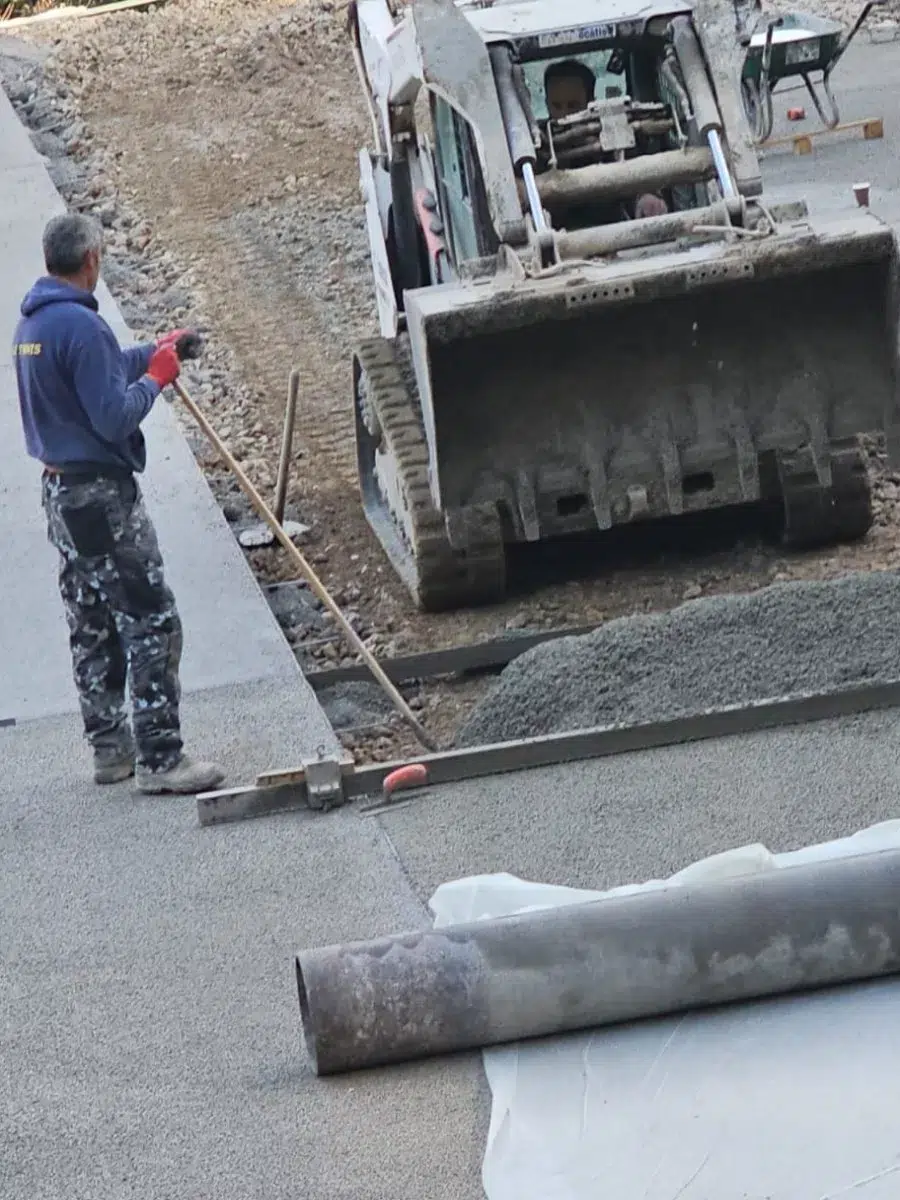 Ouvrier réglant une bordure sur le chantier d'un court