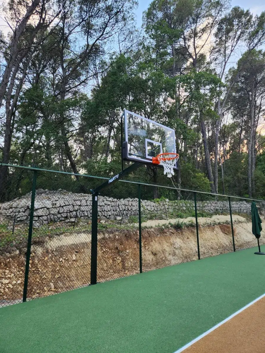 Panier de basket fixé le long d'un muret en pierre