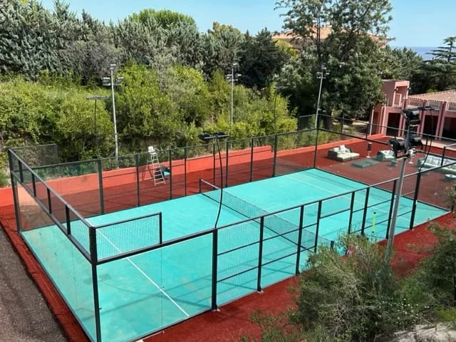 Terrain de padel turquoise vitré dans un jardin