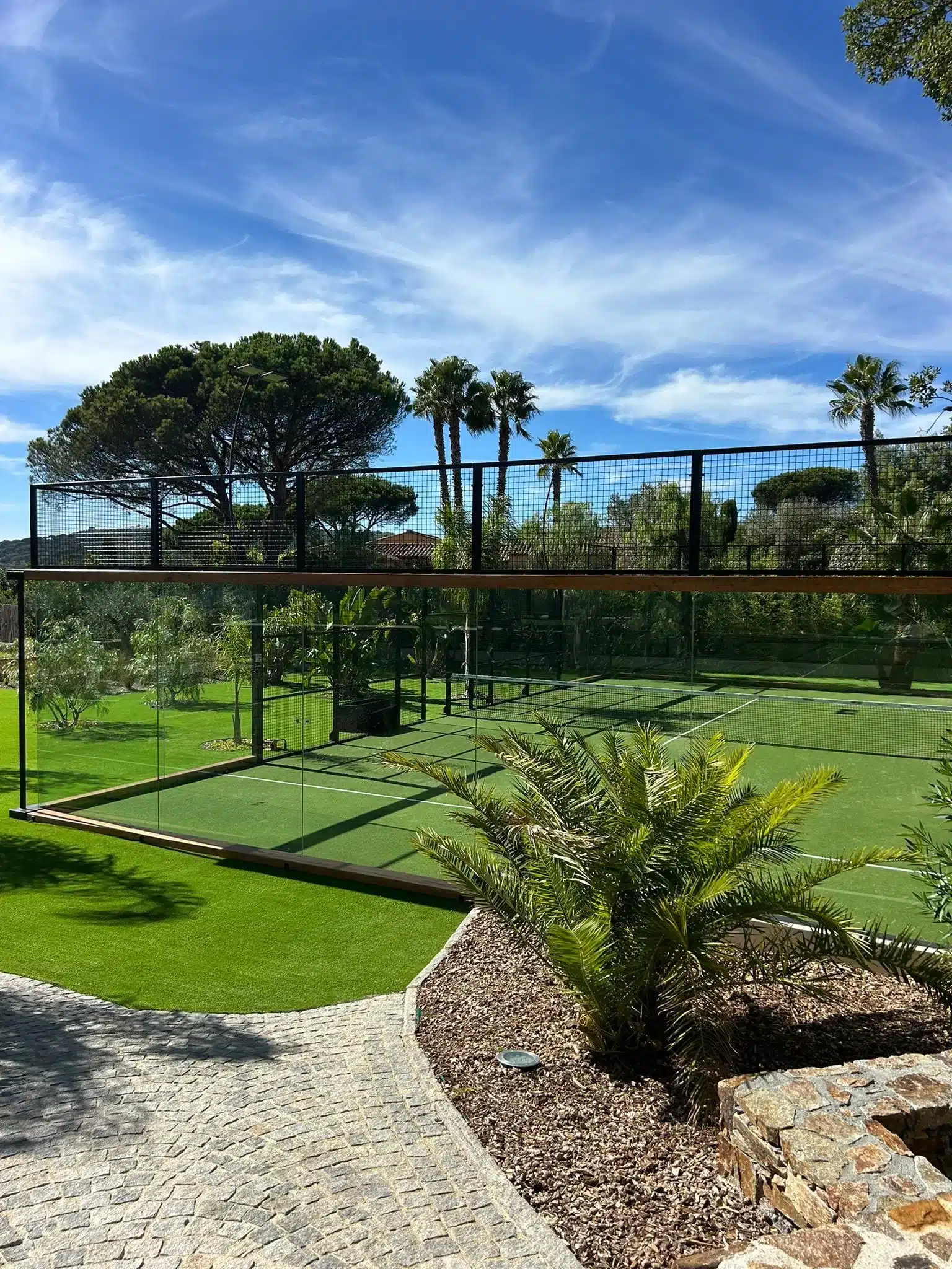Terrain de padel vitré dans un jardin méditerranéen