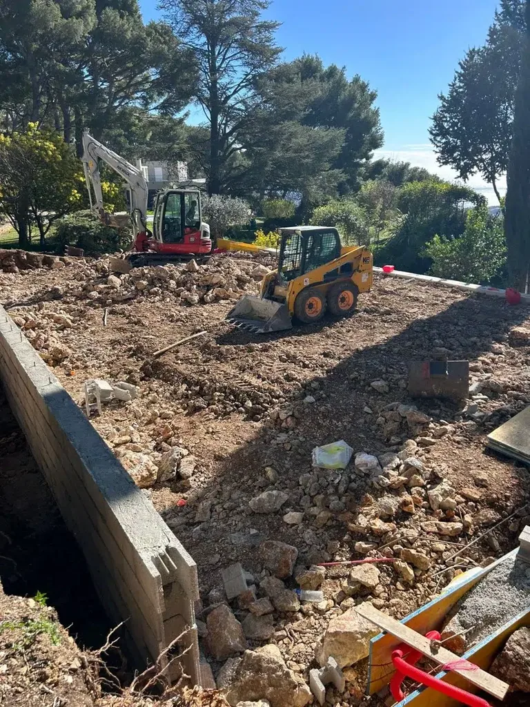 Terrassement d'un court sur un terrain en pente, engins au travail