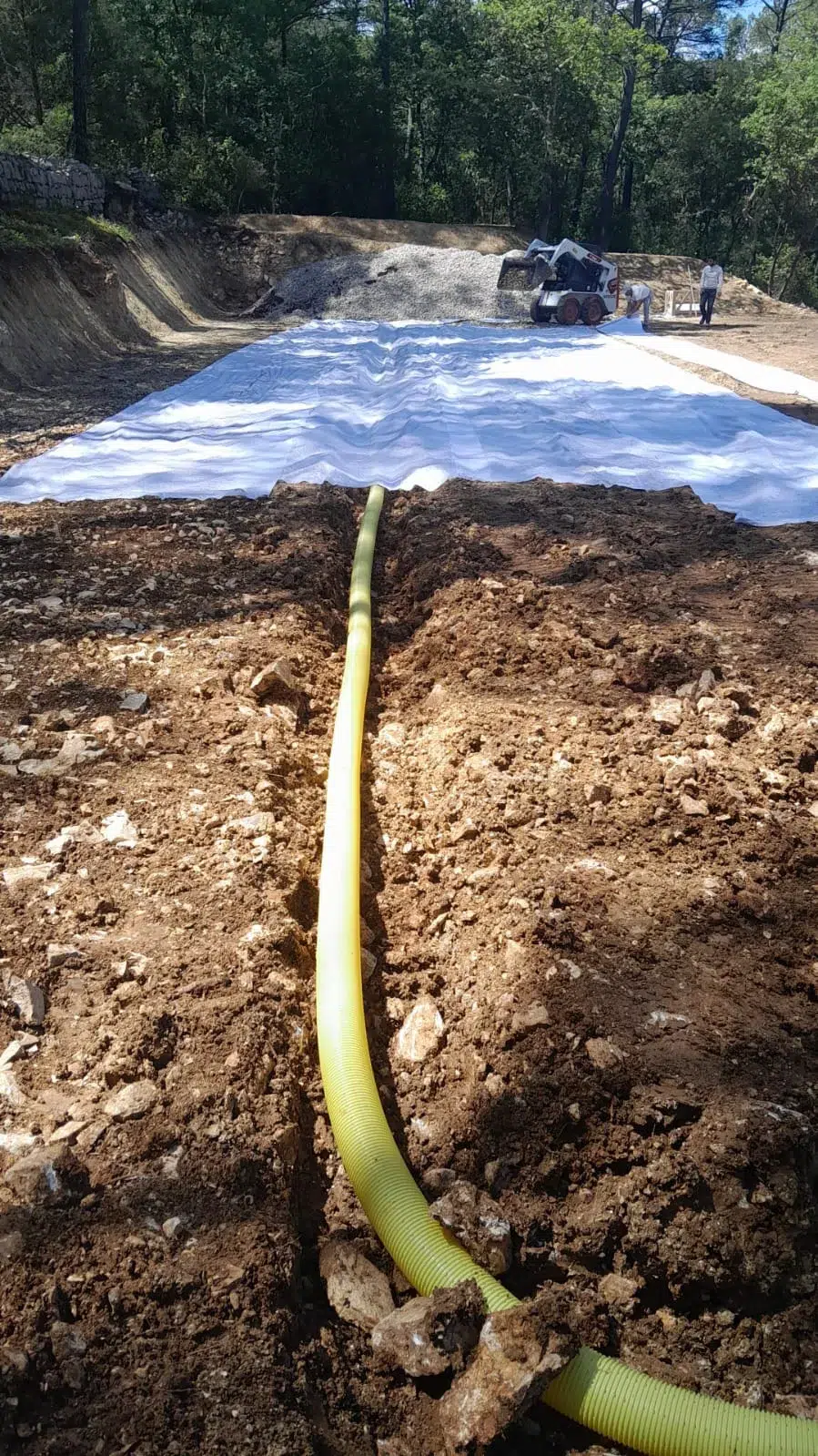 Tranchée de drainage creusée le long d'un court en construction